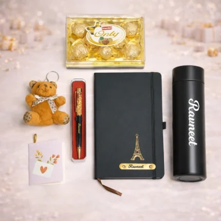 Full view of Tohfa Riwaz luxury gift box containing a personalized black diary, custom water bottle, gold-flecked pen, Ferrero-style chocolates, and a small brown teddy bear.