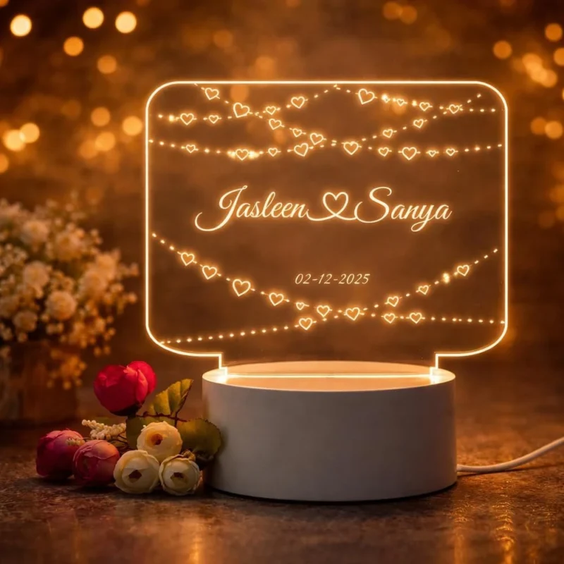 Personalized couple name LED acrylic lamp with illuminated heart designs, custom names and date on a white base.
